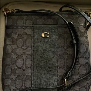 Black coach bag with long strap with gold.